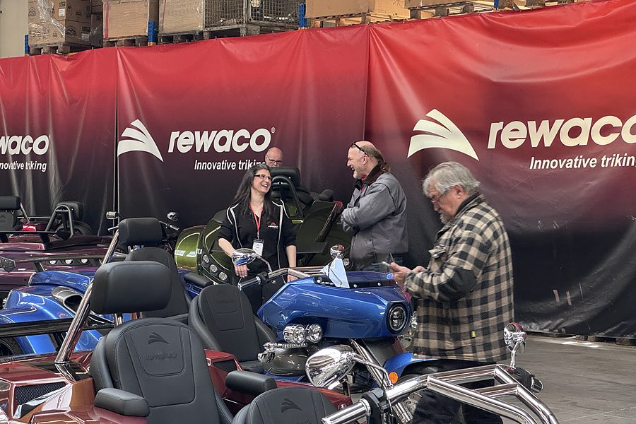 Beratungsgespräch an einem blauen rewaco Trike auf der Hausmesse 2026